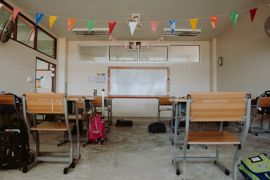 An empty classroom setup with desks and colorful banners, indicating a school setting
